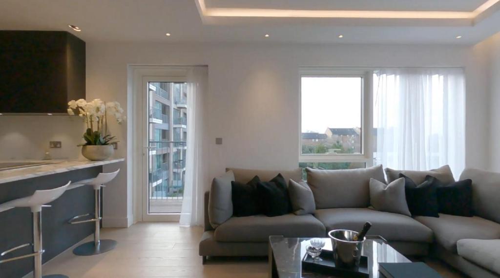 sala de estar con sofá y cocina en Chelsea Harbour 2-Bed Apartment in London, en Londres