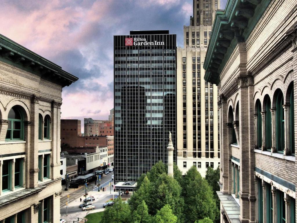 Un edificio alto con un cartel en una ciudad. en The Hilton Garden Inn Buffalo-Downtown, en Buffalo