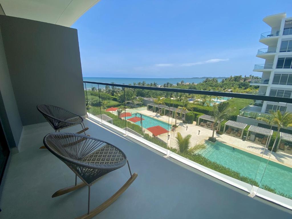 einen Balkon mit einem Stuhl und Poolblick in der Unterkunft Apartamento de Lujo Morros Zóe - Manzanillo - Cartagena in Cartagena de Indias