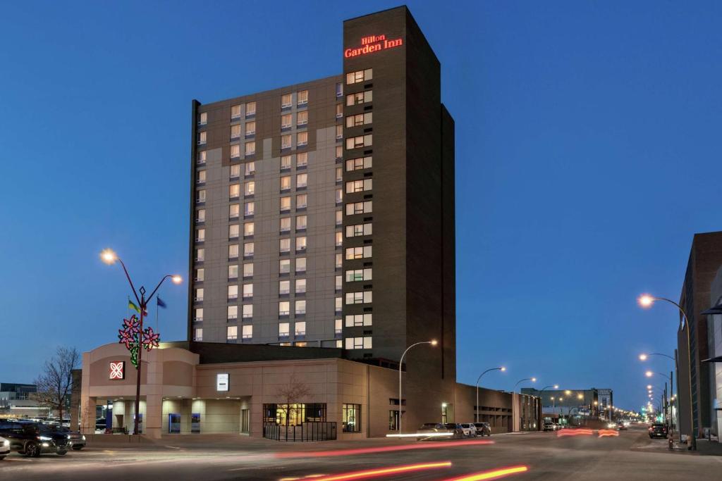 a tall building with a sign on it on a street at Hilton Garden Inn Saskatoon Downtown in Saskatoon