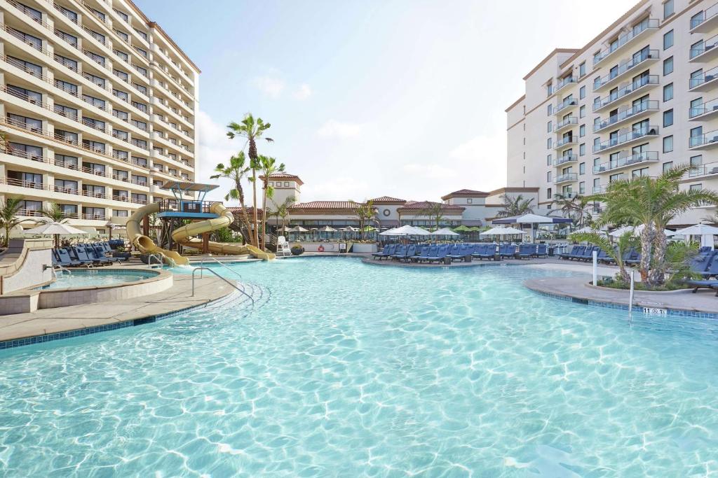 una piscina con un tobogán en un complejo en The Waterfront Beach Resort, A Hilton Hotel, en Huntington Beach