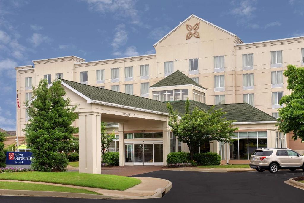 a building with a car parked in front of it at Hilton Garden Inn Frederick in Frederick