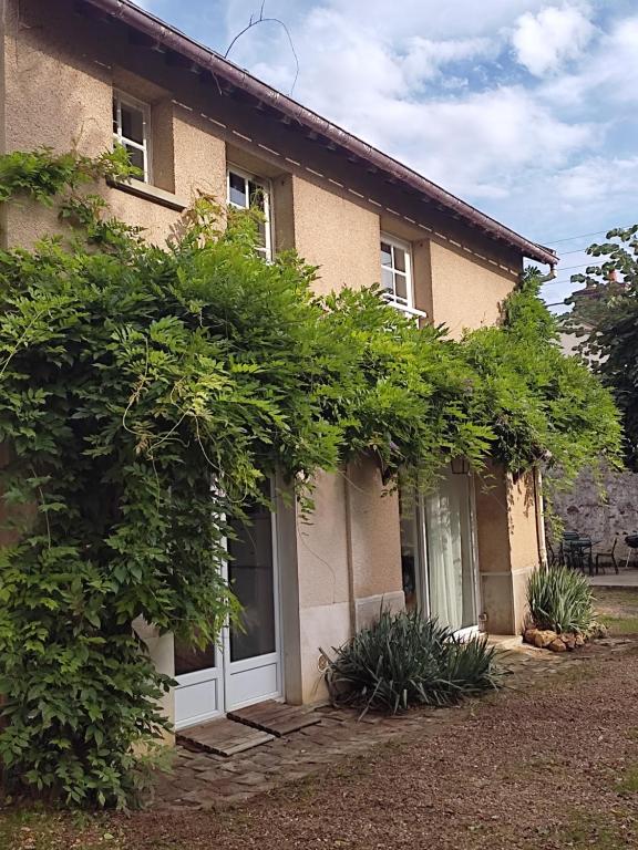 une maison avec une porte blanche et quelques buissons dans l'établissement Les Glycines, à Vulaines-sur-Seine
