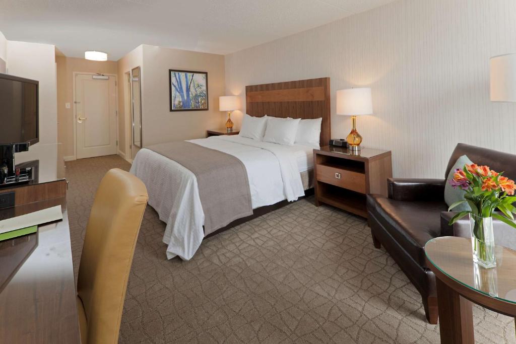 a large hotel room with a bed and a couch at DoubleTree by Hilton Pittsburgh-Green Tree in Pittsburgh
