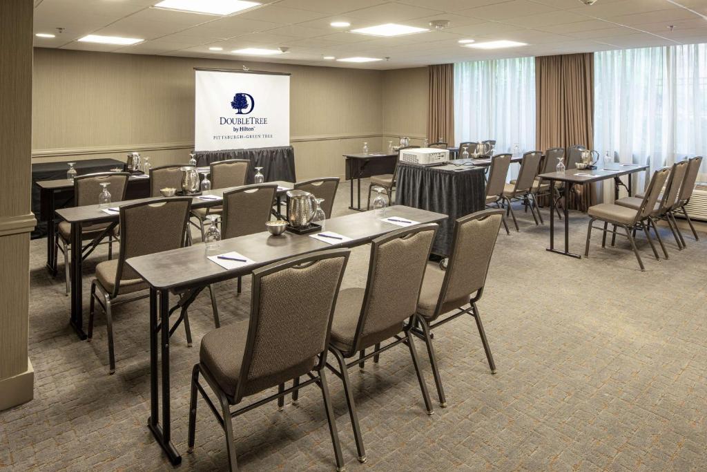 a conference room with tables and chairs and a screen at DoubleTree by Hilton Pittsburgh-Green Tree in Pittsburgh