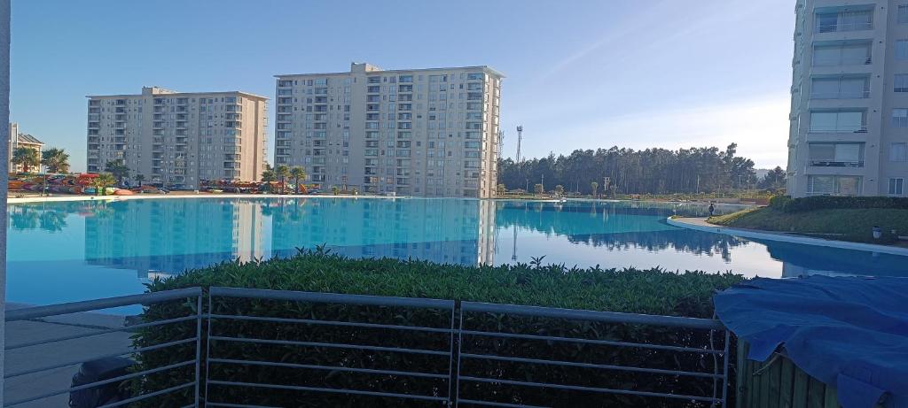 a large swimming pool in a city with tall buildings at Laguna Bahia Algarrobo in Algarrobo
