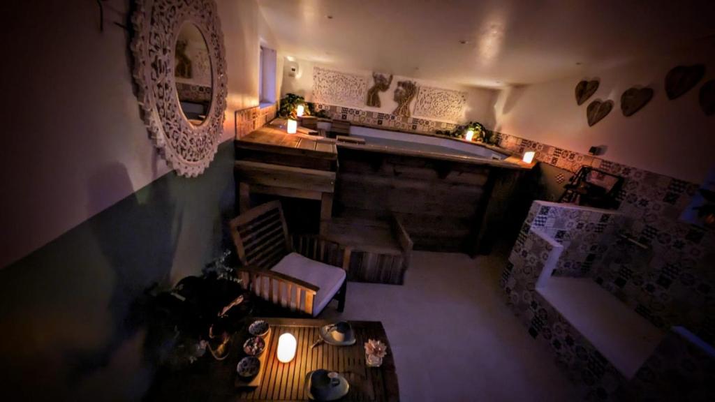 vista sul soffitto di una camera con vasca e tavolo di Studio de charme avec piscine de relaxation a Moyaux