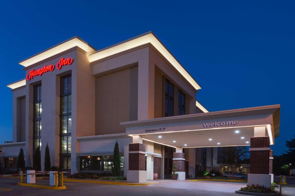 a hotel with a sign on the front of a building at Hampton Inn Norcross in Norcross