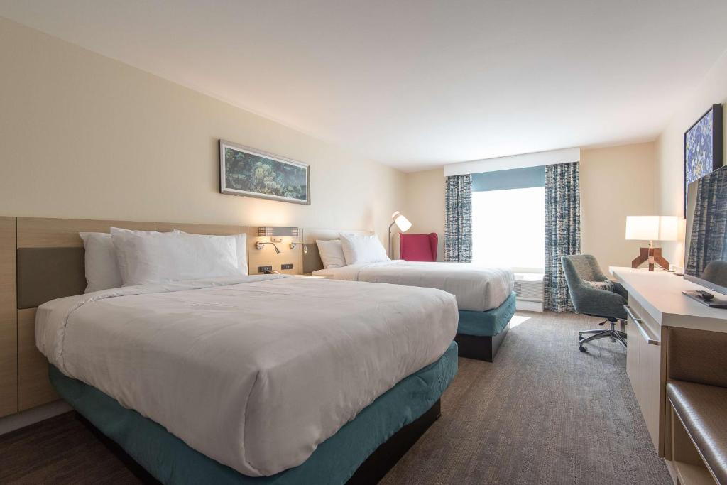 ein Hotelzimmer mit zwei Betten und einem Schreibtisch in der Unterkunft Hilton Garden Inn Calabasas in Calabasas