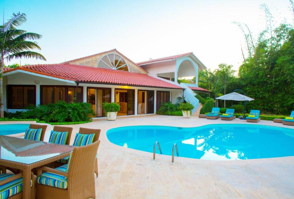 a villa with a swimming pool in front of a house at Sunny Vacation Villa No 93 in San Rafael del Yuma