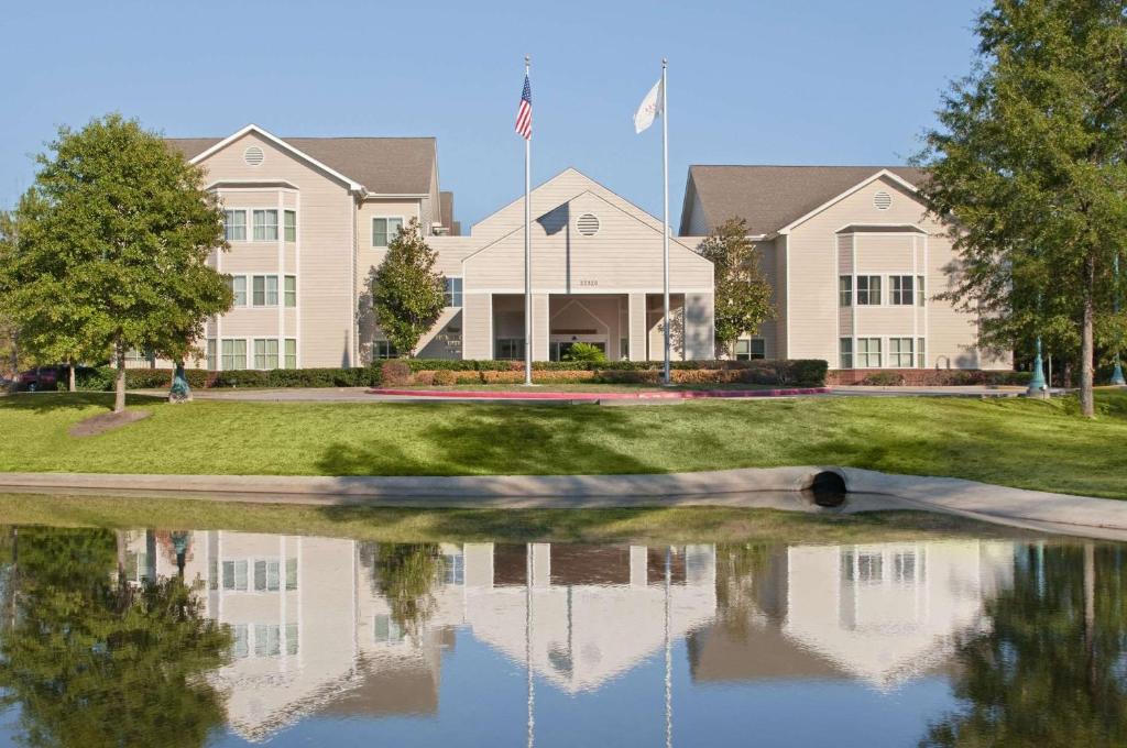 una casa con un reflejo en el agua en Homewood Suites Houston Kingwood Parc Airport Area, en Kingwood