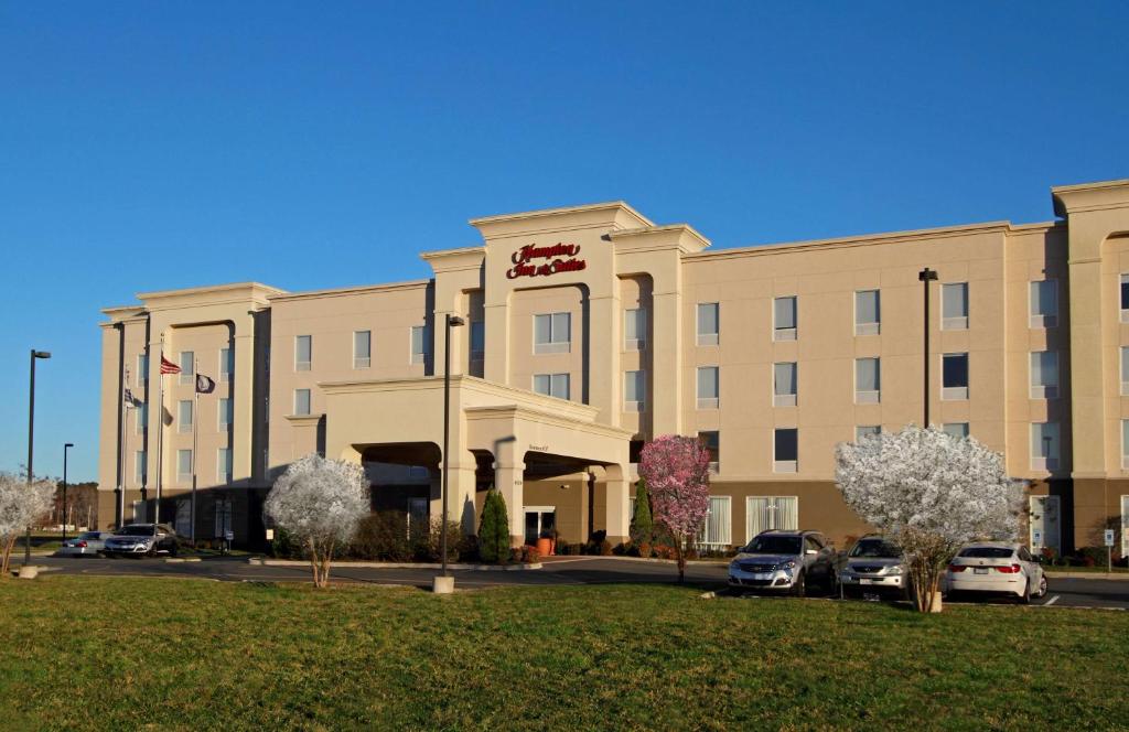 un grand bâtiment avec des voitures garées devant lui dans l'établissement Hampton Inn & Suites Exmore - Eastern Shore, à Exmore