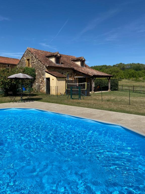 a house with a blue swimming pool in front of a house at Peaceful, comfortable retreat with pool in Montcléra