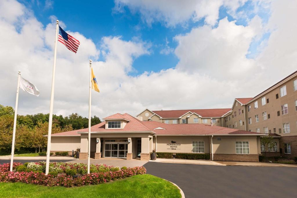 un hotel con due bandiere di fronte a un edificio di Homewood Suites by Hilton Princeton a Princeton