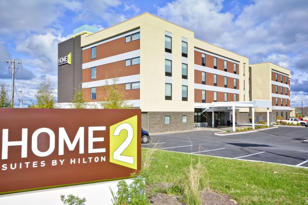 una señal de hotel frente a un edificio en Home2 Suites By Hilton Oswego, en Oswego