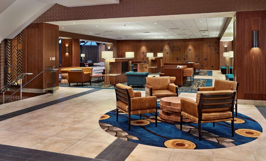 a lobby of a hotel with chairs and tables at DoubleTree by Hilton Hotel & Conference Centre Regina in Regina