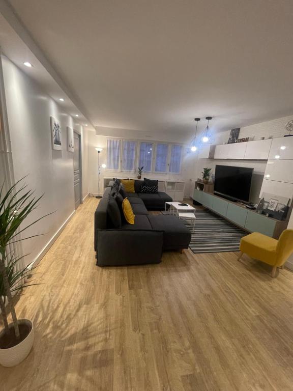 uma sala de estar com um sofá preto e uma televisão em Big flat Brest em Brest
