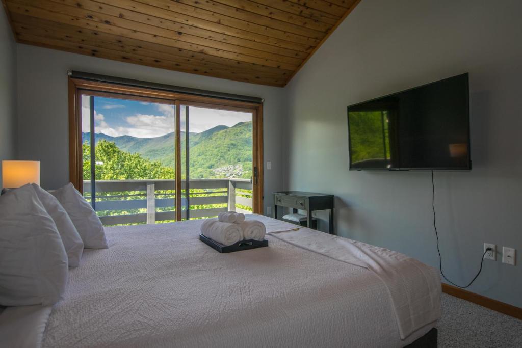 a bedroom with a large bed with a large window at Modern, Sleeps 6, Amazing Views in Maggie Valley