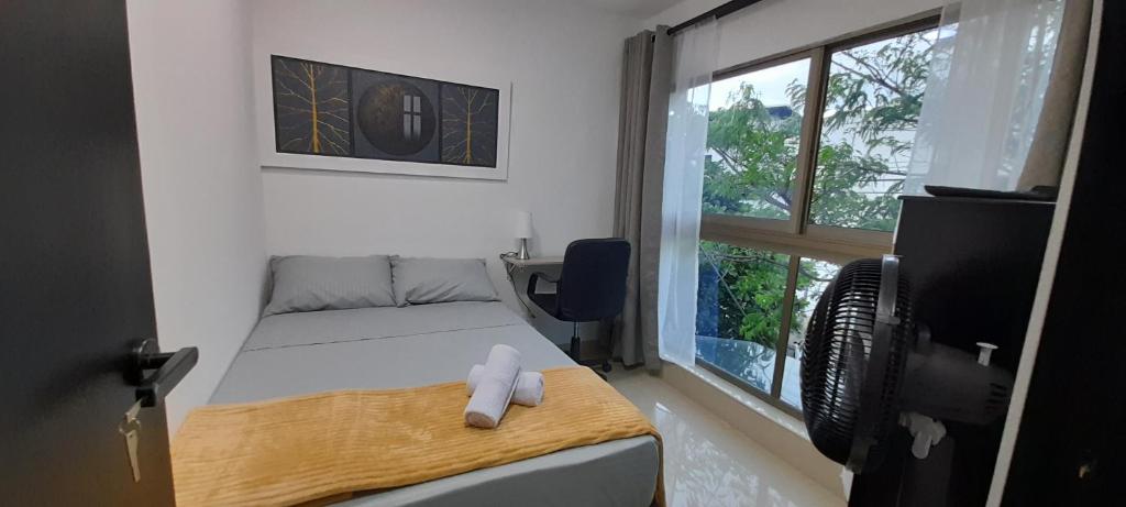 a small bedroom with a bed and a window at Equilibrio Shalom Living in Medellín