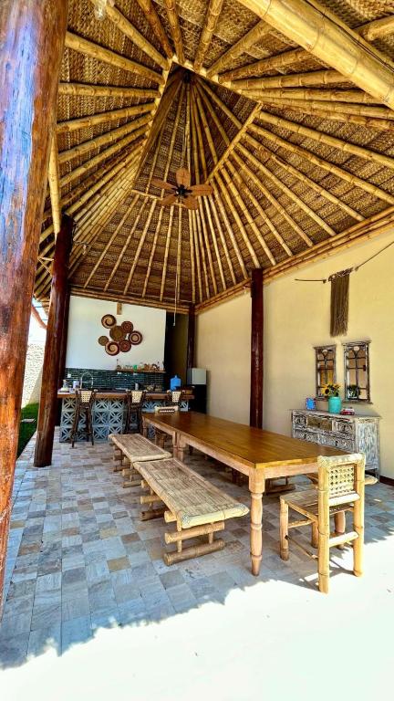 a large room with a wooden table and a large umbrella at IGUANA HOUSE in Máncora