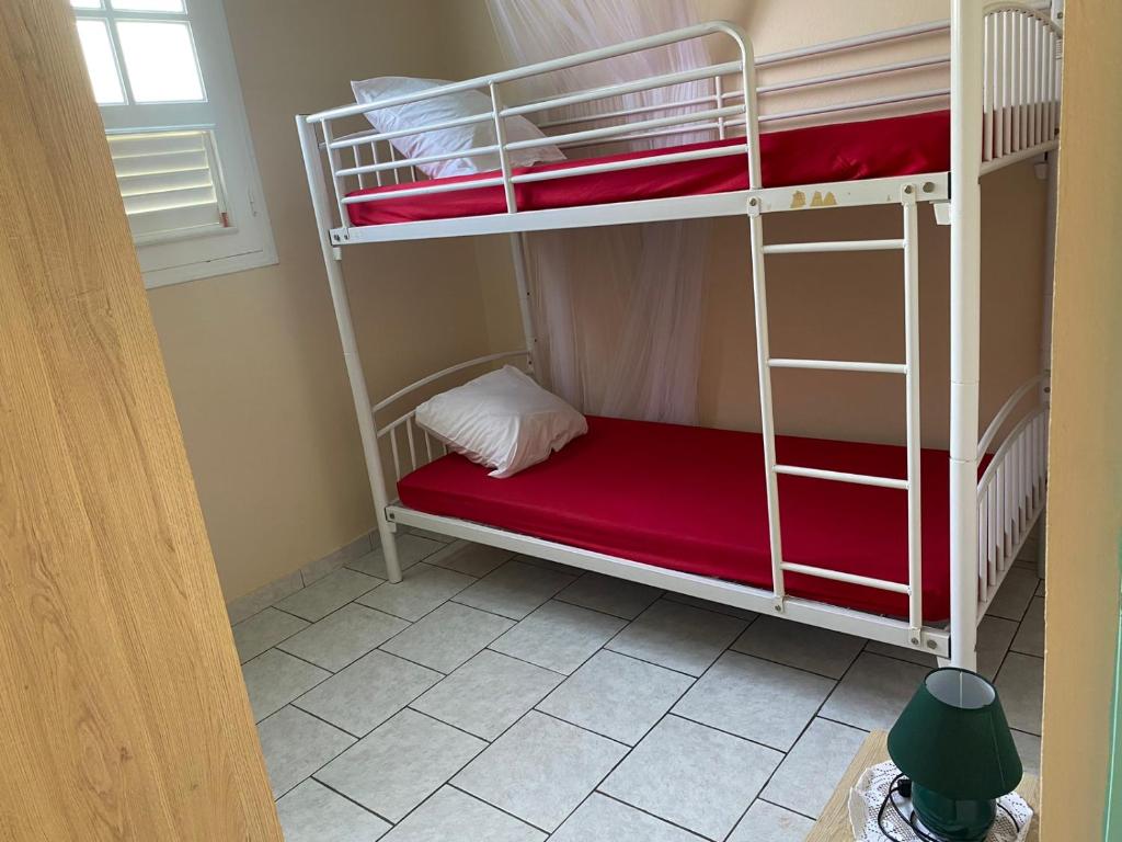 a room with two bunk beds with a red mattress at La Belle Escapade in Quartier du Fond Fleuri