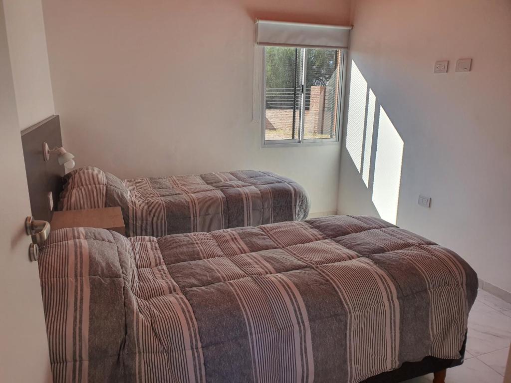 a bedroom with two beds and a stair case at Complejo familia Yedynak in San Rafael