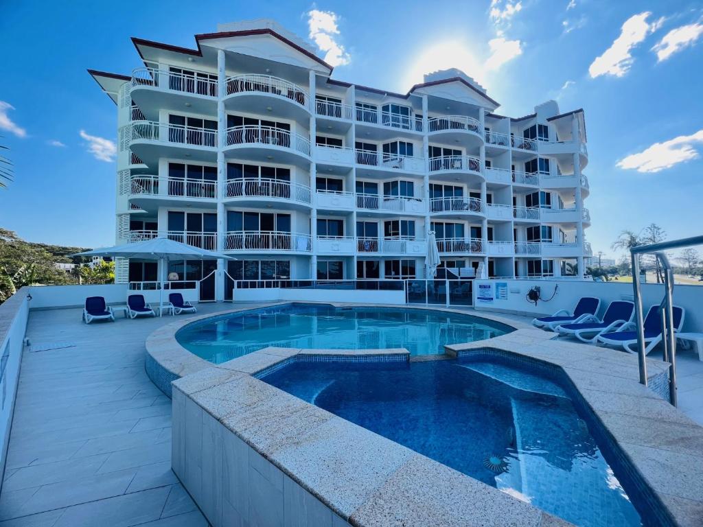 un gran edificio de apartamentos con piscina en Aquarius Resort, en Alexandra Headland