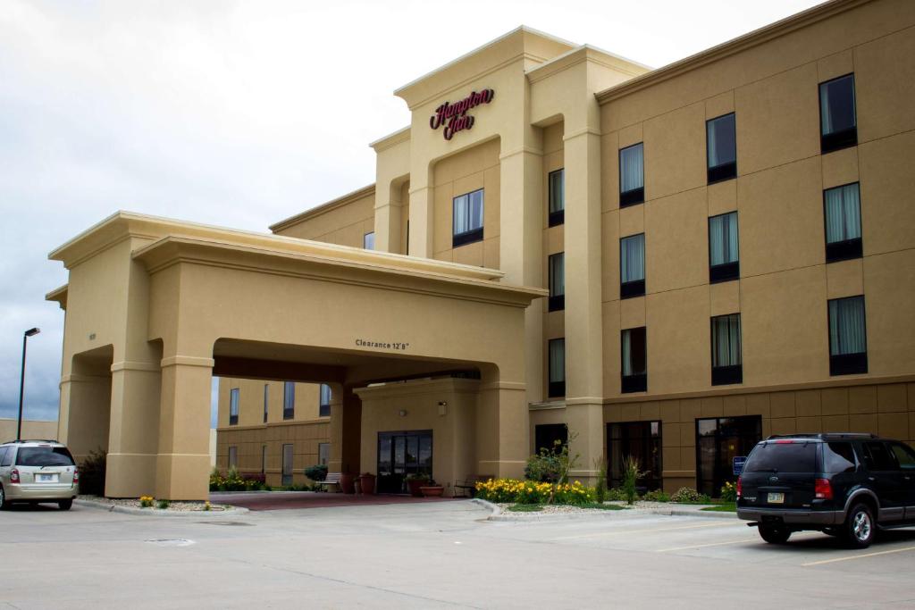 a hotel with cars parked in a parking lot at Hampton Inn Junction City in Junction City