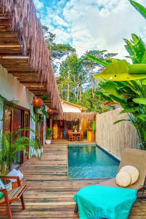 a house with a swimming pool and a wooden deck at Casa Rudá Condominio Icatu in Trancoso