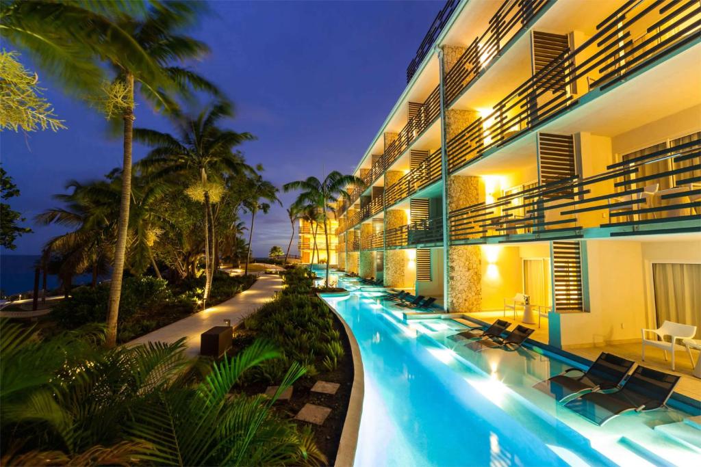 um hotel com piscina à noite em Sonesta Ocean Point Resort- All Inclusive - Adults Only em Maho Reef