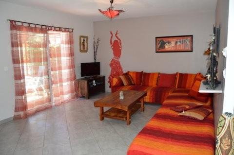 la Villa rouge Ardèche "le Baya" في Ucel: غرفة معيشة بها أريكة وطاولة