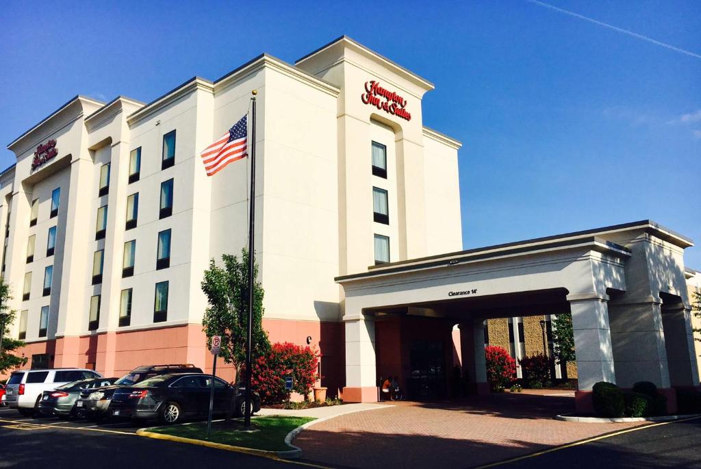 a hotel building with an american flag in front of it at Hampton Inn & Suites Chesapeake-Battlefield Boulevard in Chesapeake