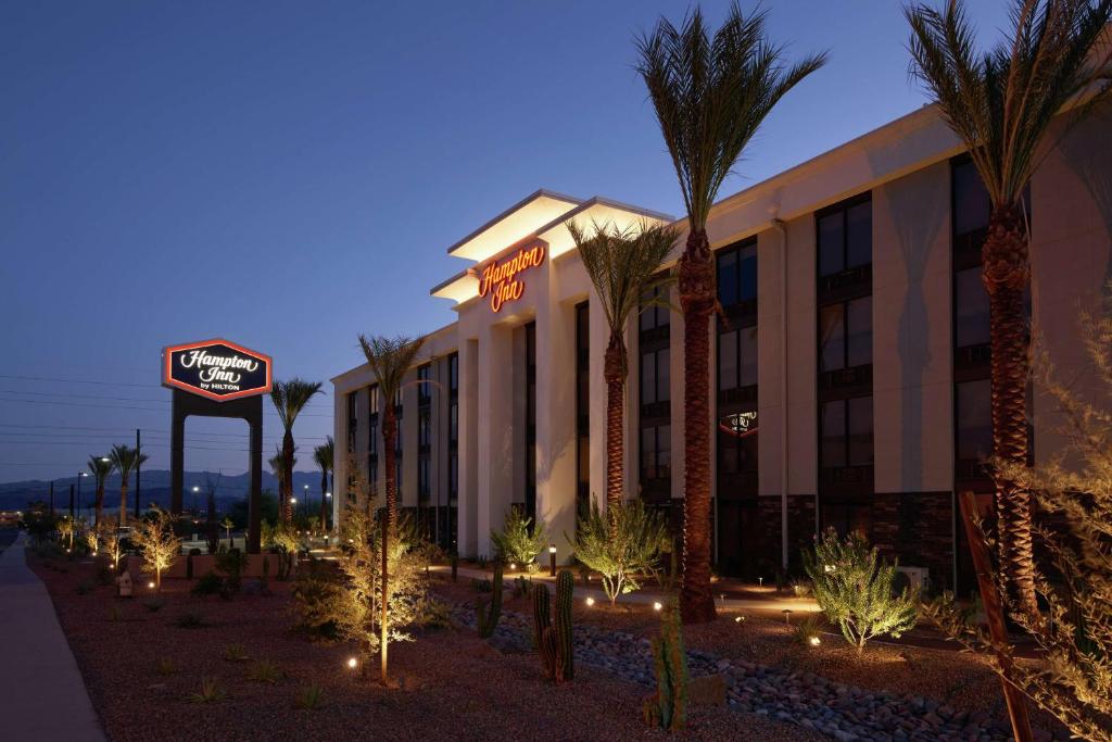 un hotel con palmeras y un cartel de hotel por la noche en Hampton Inn Lake Havasu City, en Lake Havasu City