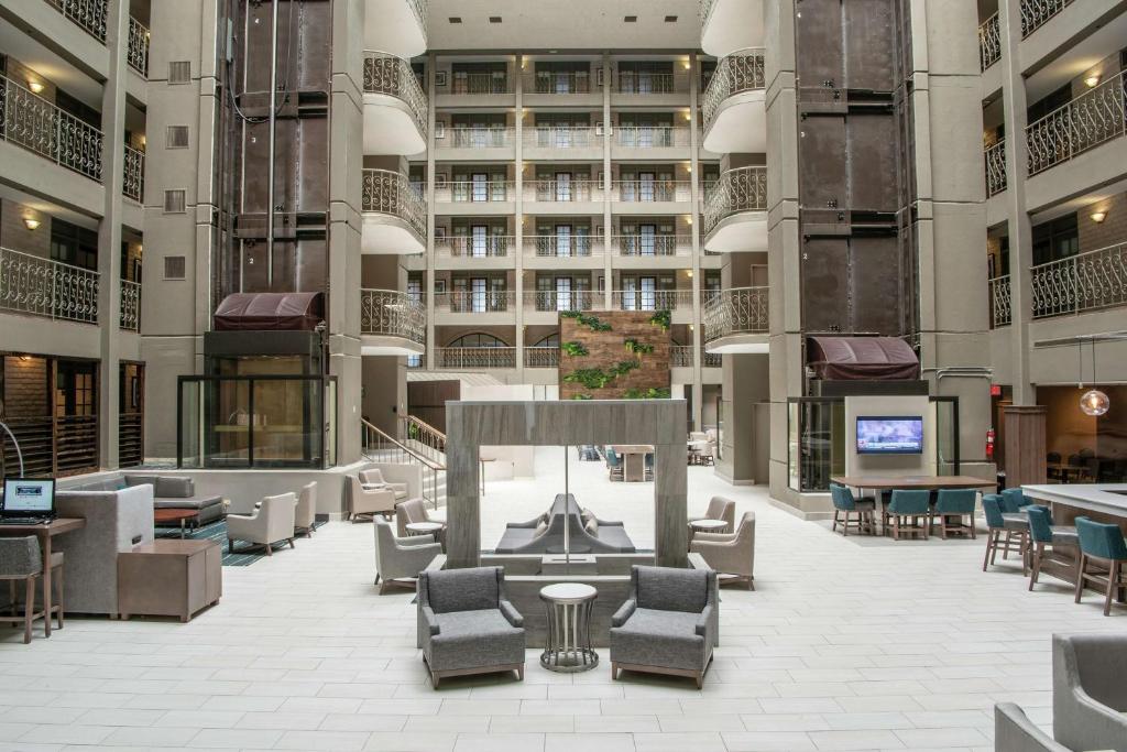 an empty lobby of a building with chairs and tables at Embassy Suites by Hilton Chicago Schaumburg Woodfield in Schaumburg