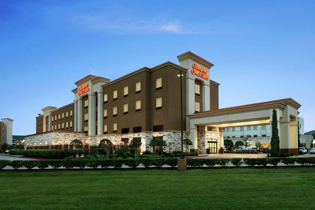 a hotel building with a lawn in front of it at Hampton Inn and Suites Houston Pasadena in Pasadena