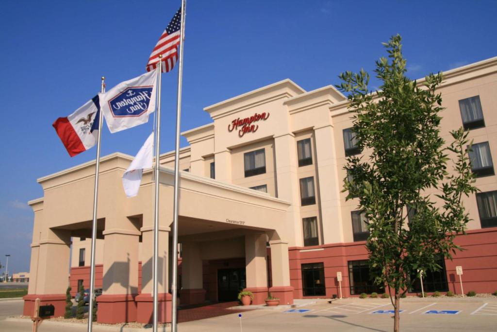 a building with three flags in front of it at Hampton Inn Waterloo in Waterloo