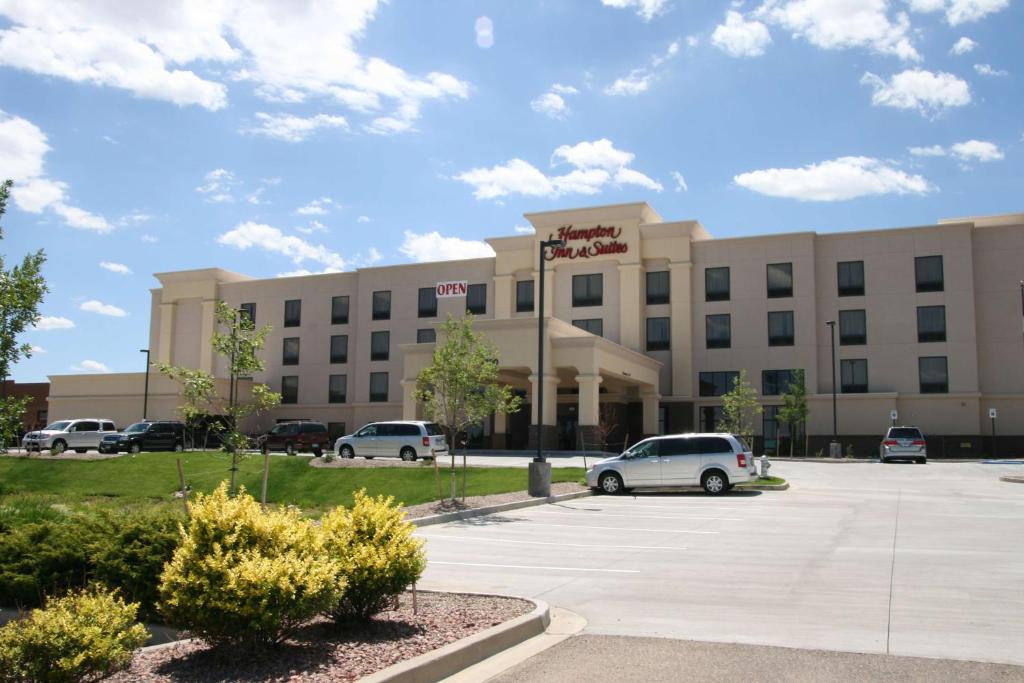 un gran edificio con coches estacionados en un estacionamiento en Hampton Inn and Suites Pueblo/North, en Pueblo