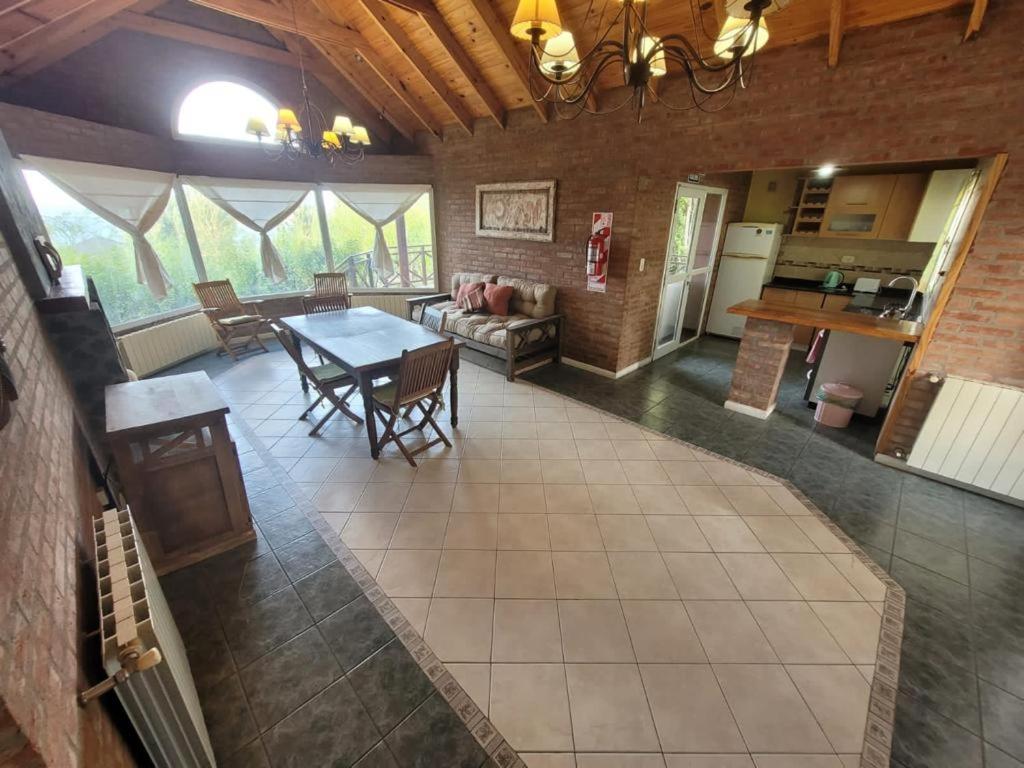 a large living room with a table and a kitchen at Casa Lago Argentino in El Calafate