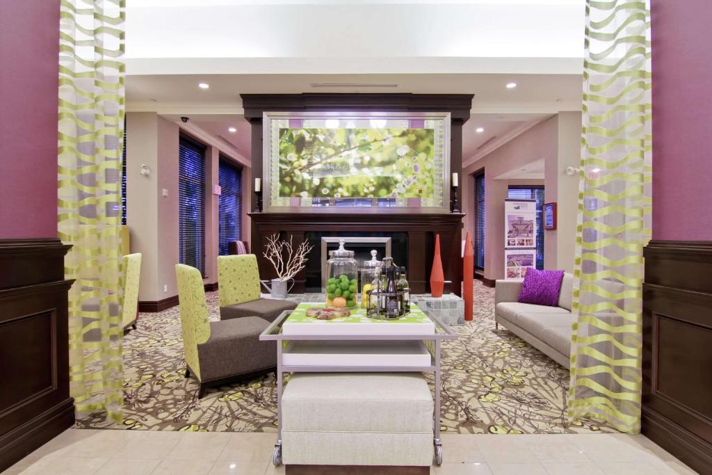 a lobby with a table and chairs and a fireplace at Hilton Garden Inn Toronto/Ajax in Ajax