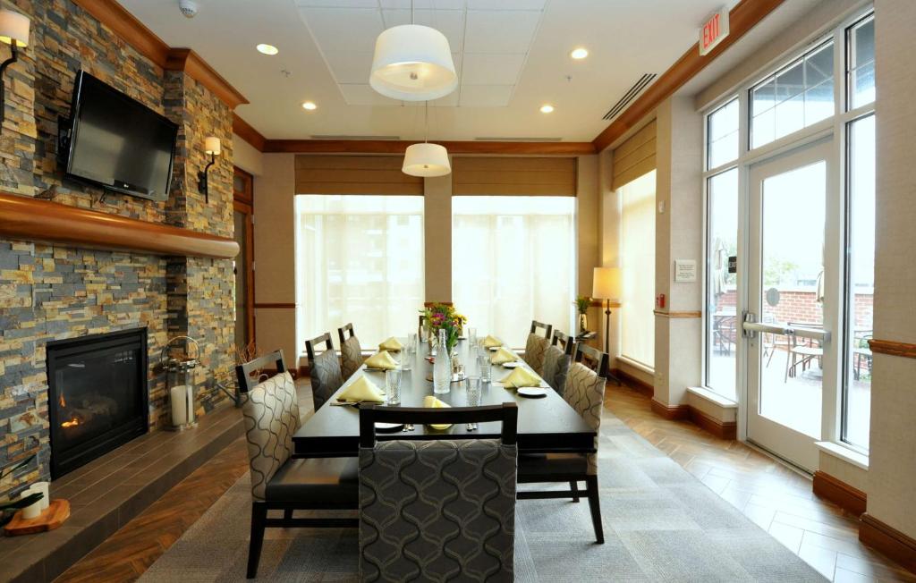 a dining room with a table and a fireplace at Hilton Garden Inn Clifton Park in Clifton Park