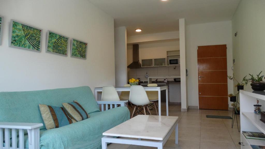 een woonkamer met een blauwe bank en een keuken bij Departamento de dos ambientes a 60 metros de la plaza de Adrogué in Adrogué