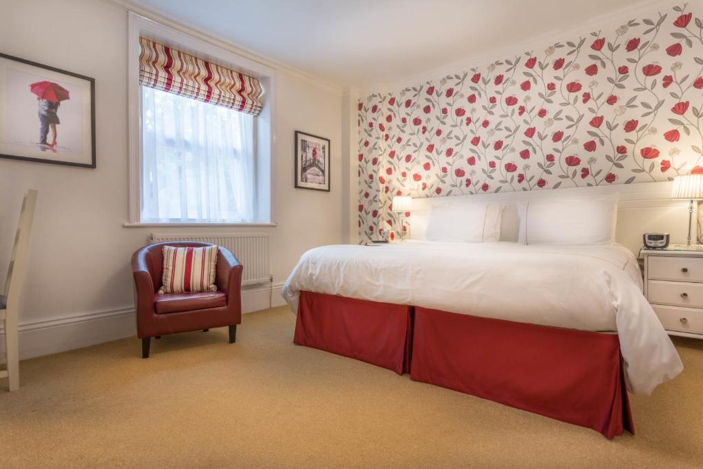 a bedroom with a large bed and a chair at Balincourt in Bournemouth