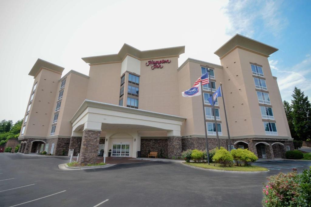 a hotel with an american flag in a parking lot at Hampton Inn Salem East - Electric Road in Salem