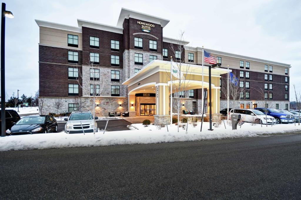 a large building with cars parked in front of it at Homewood Suites by Hilton Novi Detroit in Novi