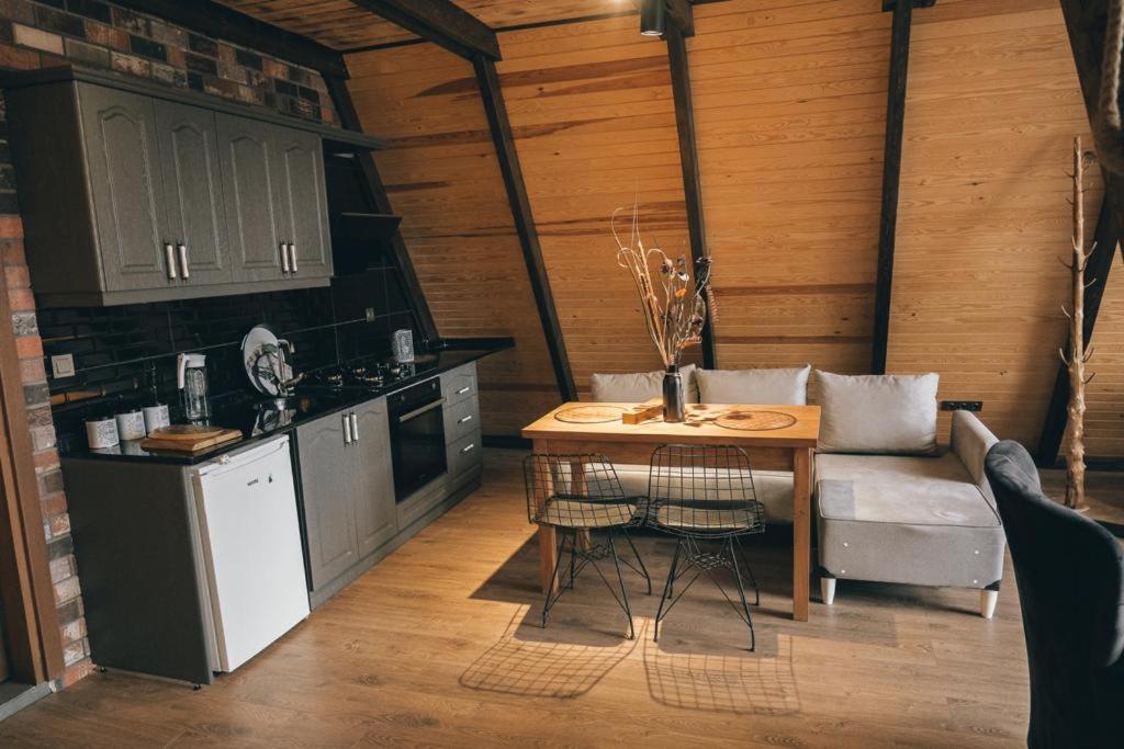 a kitchen with a table and a couch in a room at Greenworldbungalov2 in Sapanca