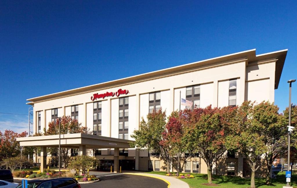 un gran edificio blanco con un letrero rojo. en Hampton Inn Philadelphia-Airport en Filadelfia