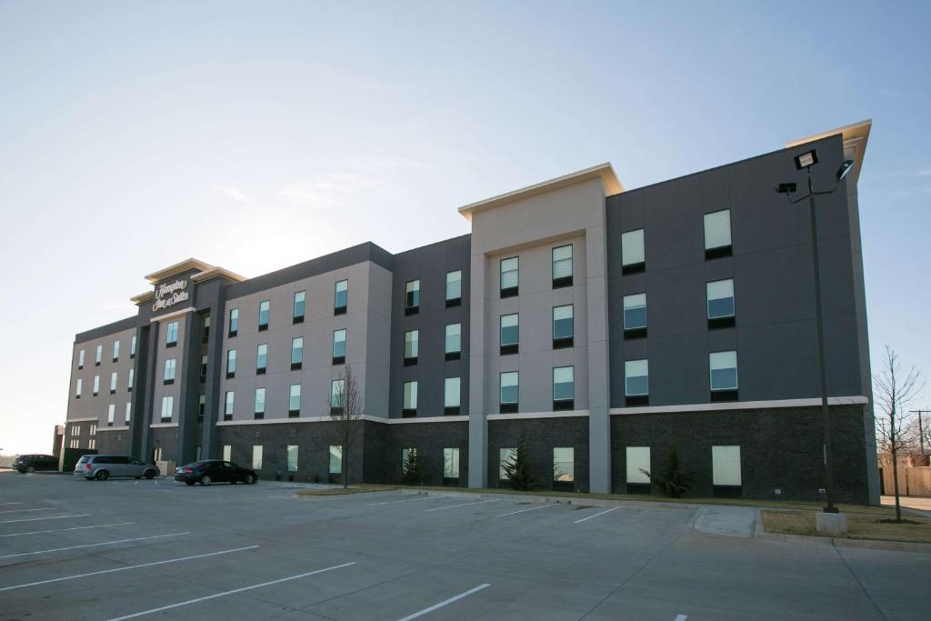 a large building with a parking lot in front of it at Hampton Inn & Suites Stroud in Stroud
