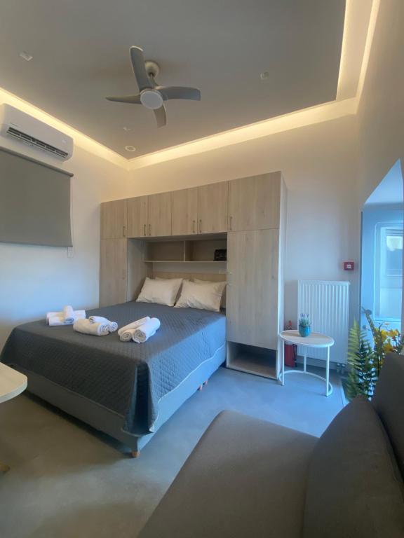 1 dormitorio con 1 cama grande y ventilador de techo en Serendipity Living Studio, en Citera