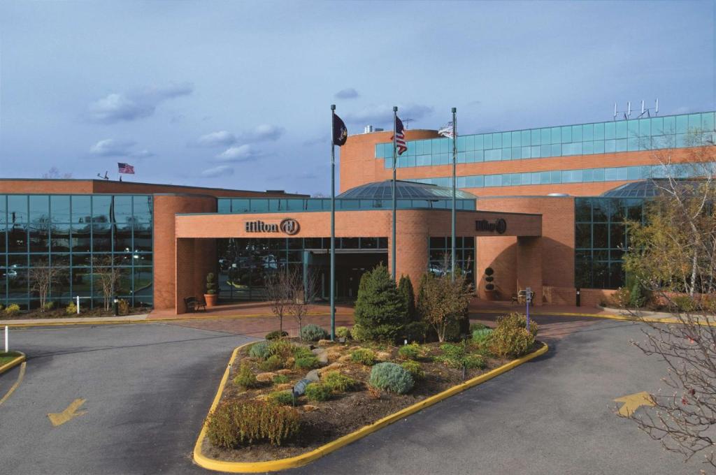 a building with a parking lot in front of it at Hilton Long Island/Huntington in Melville