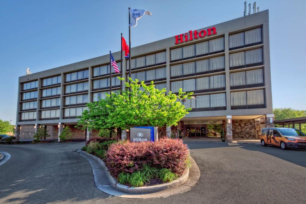 um hotel com uma bandeira em frente a um edifício em Hilton Knoxville Airport em Alcoa